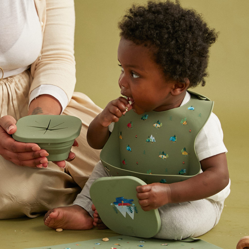 green silicone feeding bib and snack bowl in matching camping print