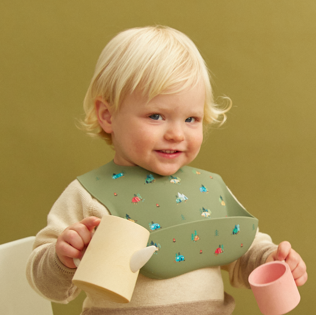 green silicone feeding bib with front pocket in camping print