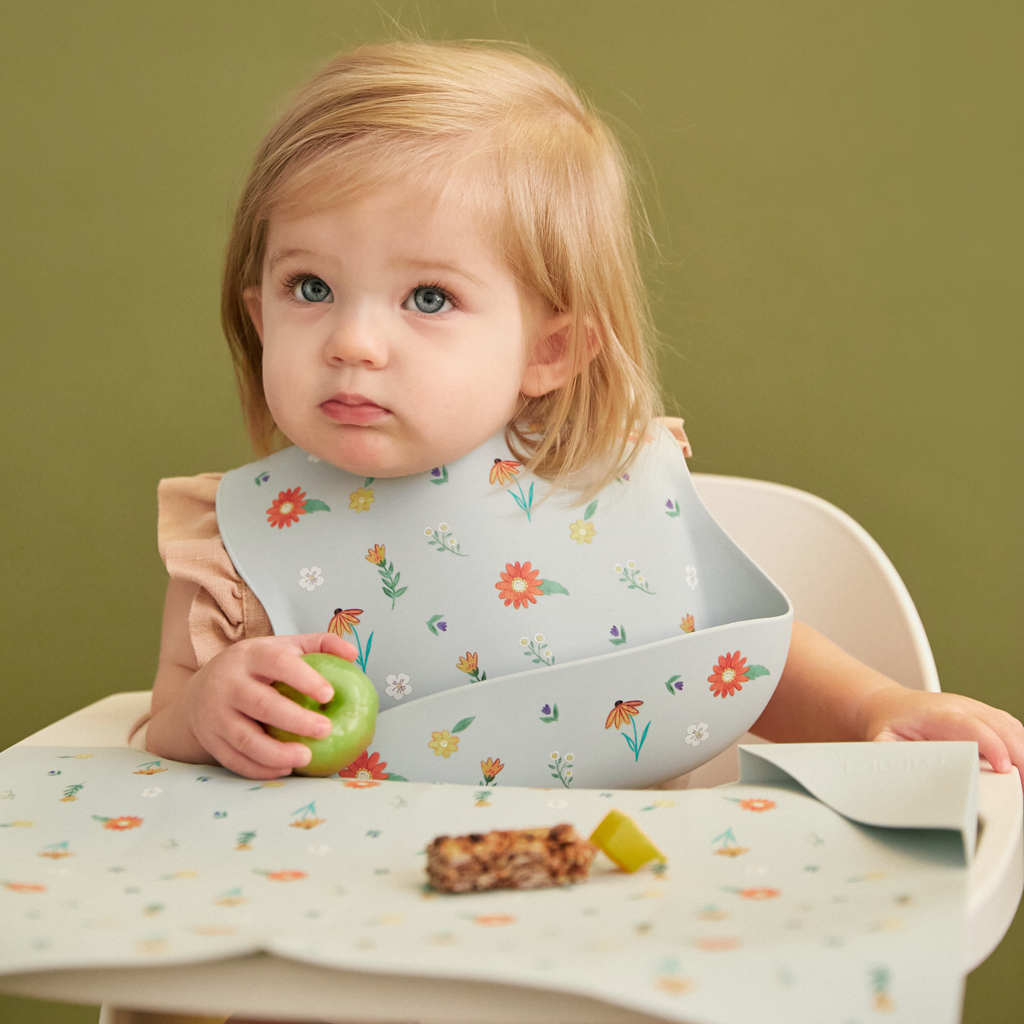 light blue silicone feeding bib with front pocket in wildflower print