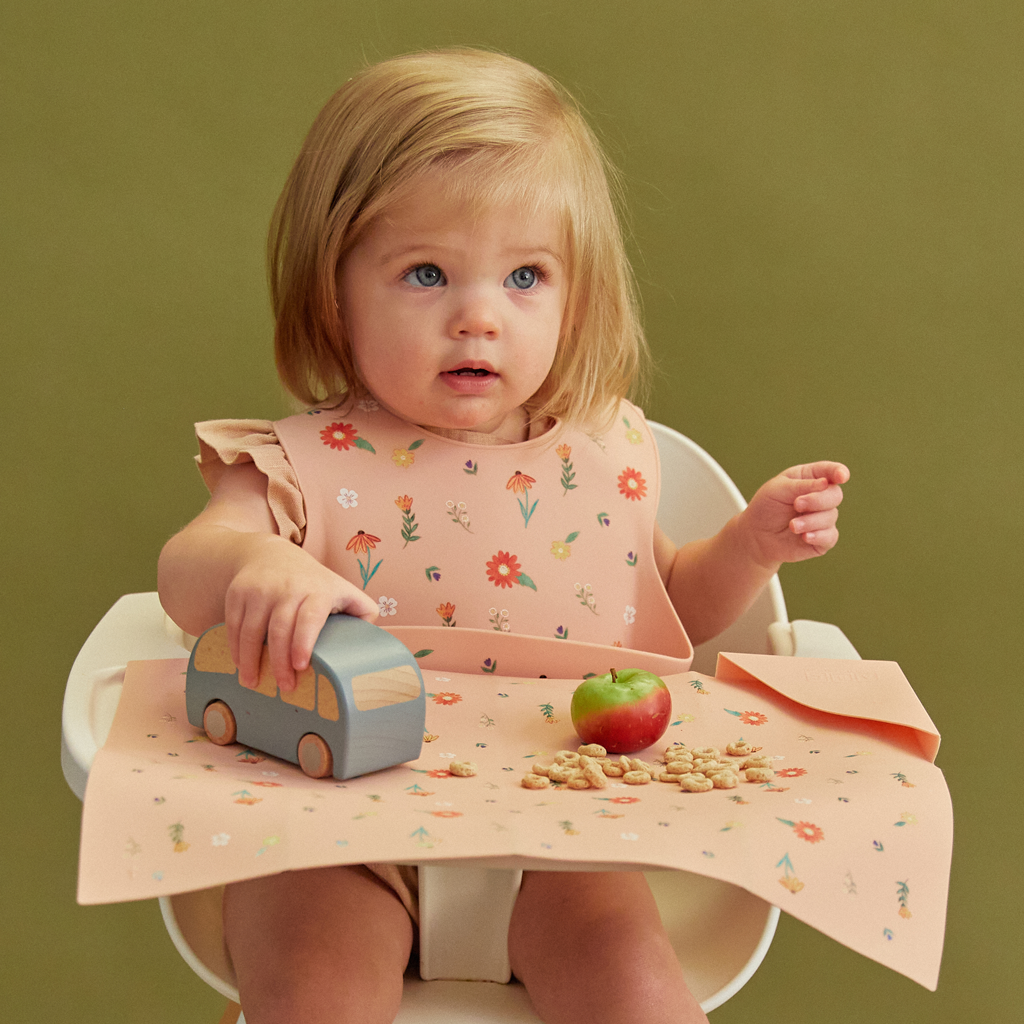 pink silicone feeding bib with front pocket in wildflower print