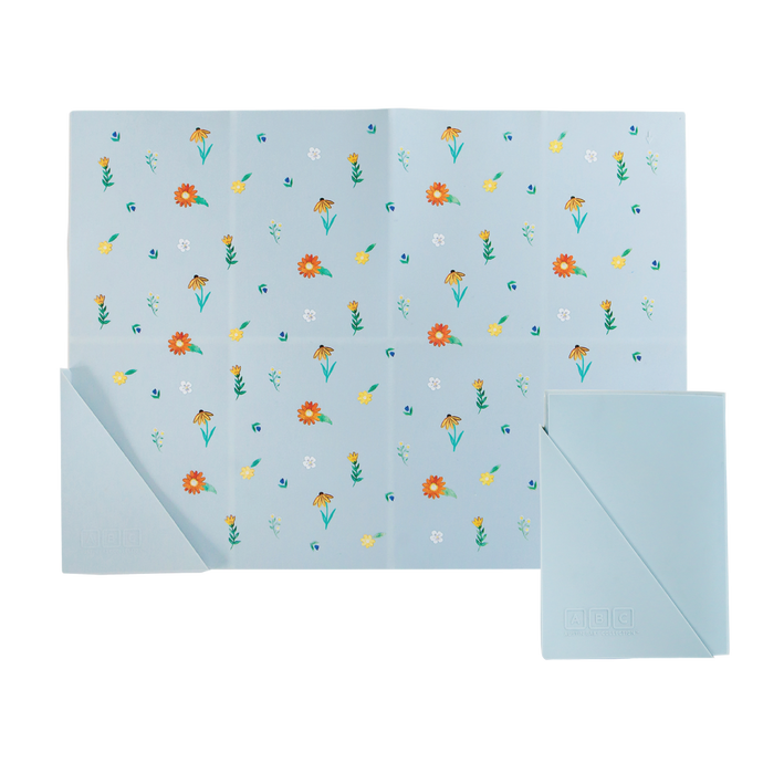 light blue silicone placemat in wildflower print, shown folded and unfolded