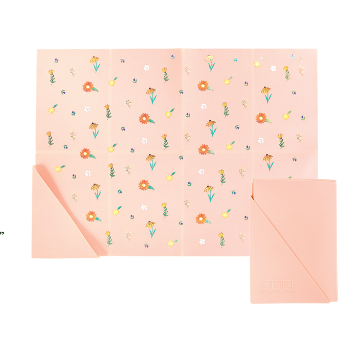 pink silicone placemat in wildflower print, shown folded and unfolded