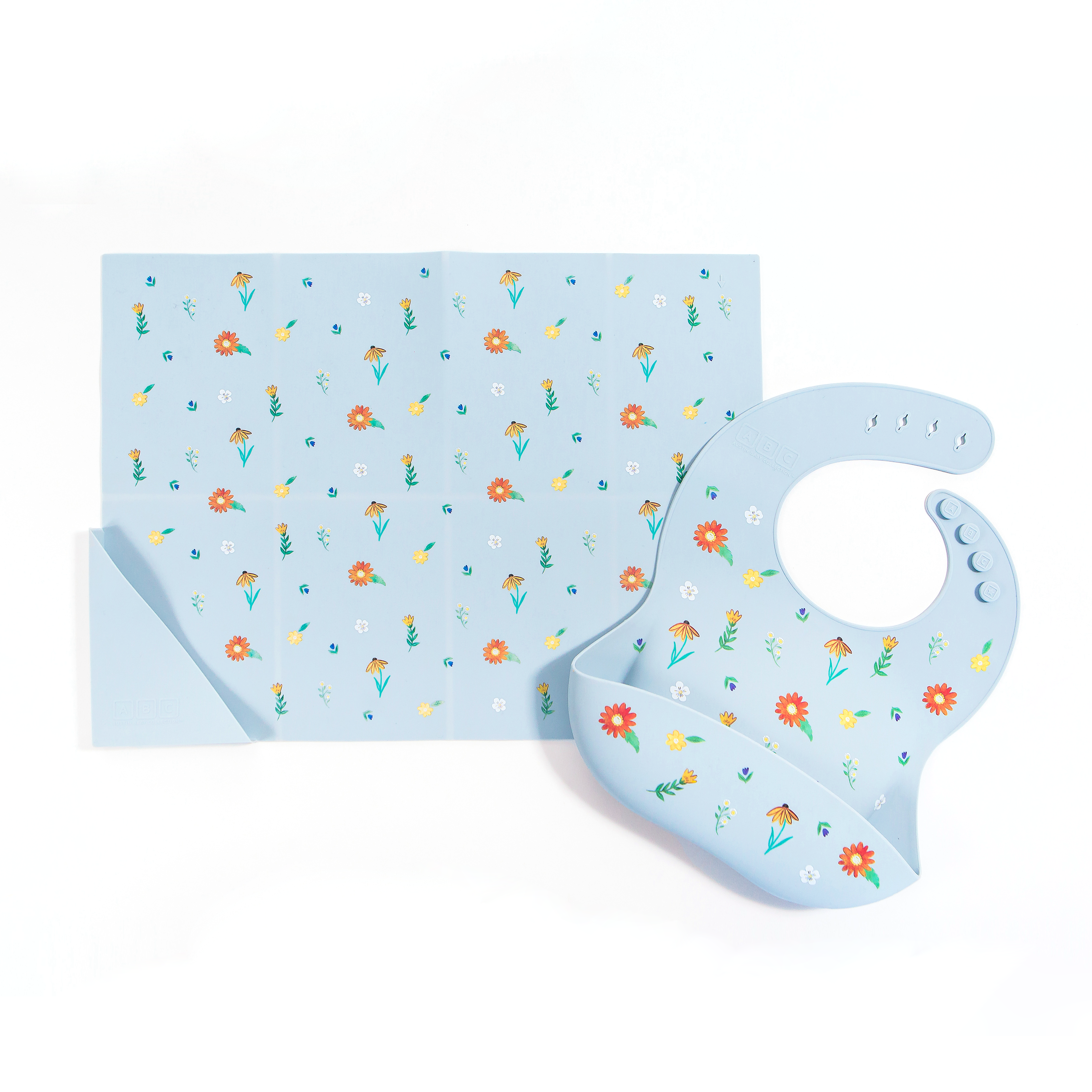 light blue silicone placemat in wildflower print, with matching feeding bib